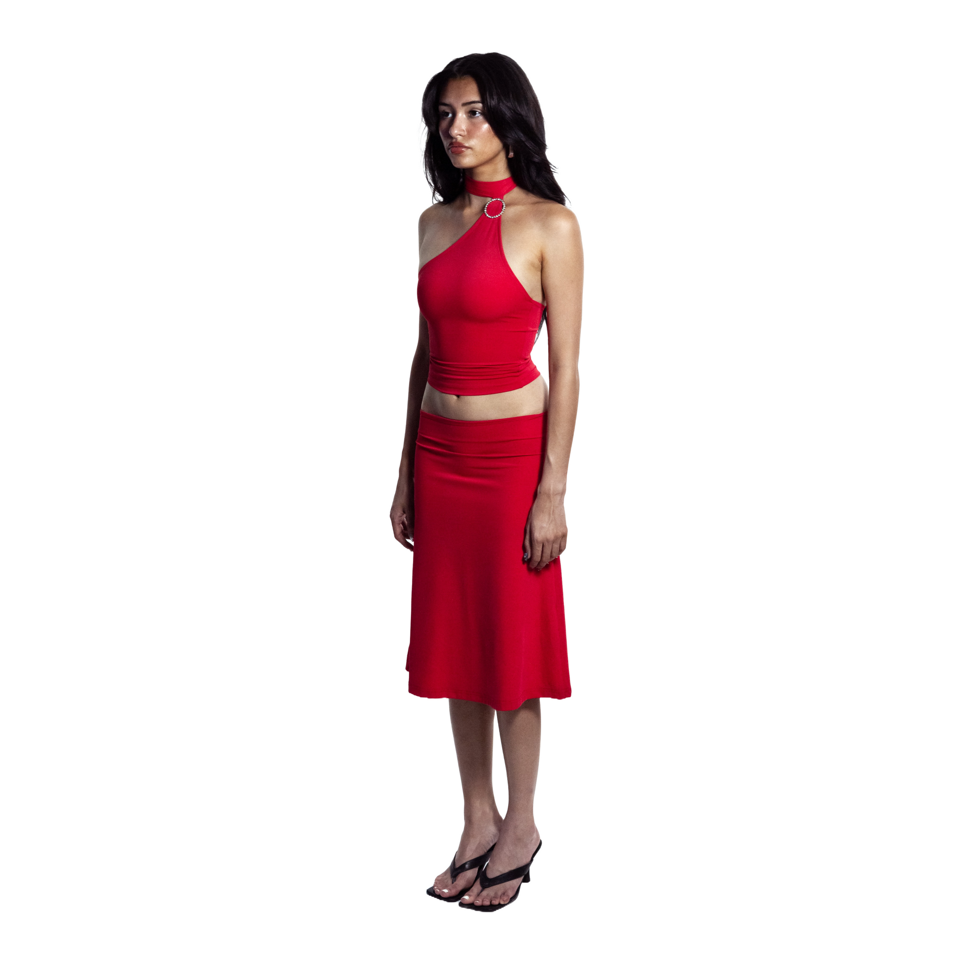 Full body side view of barbados red self-tieing asymetrical top with circle brooch and midi knee-length skirt