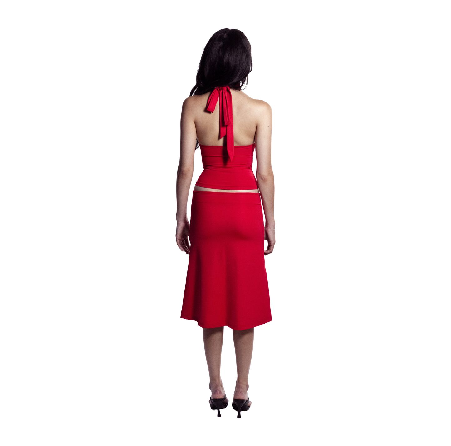 Full body back view of barbados red self-tieing asymetrical top with circle brooch and midi knee-length skirt